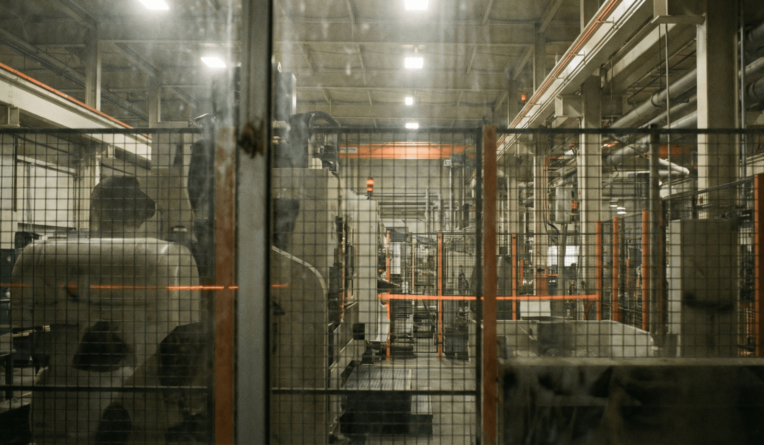 Línea de fabricación vista a través de una barrera que representa visibilidad limitada
